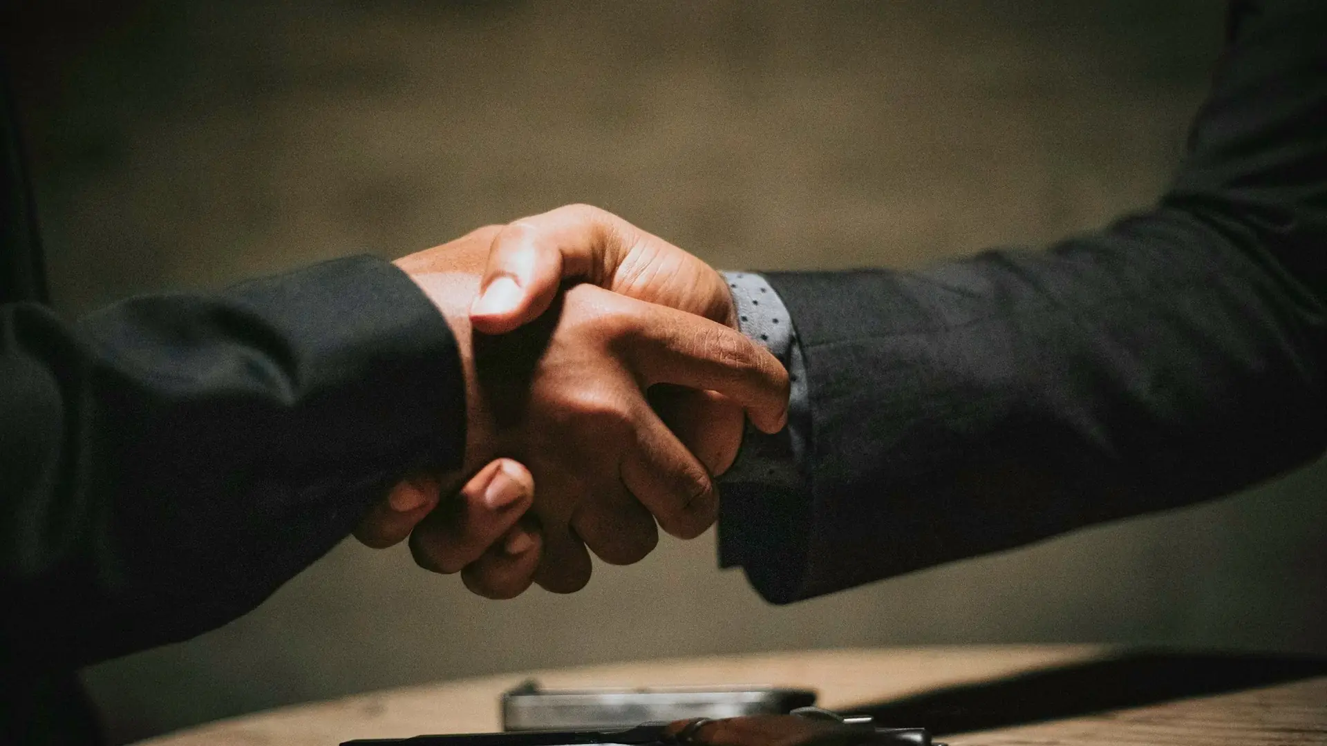 Dos personas cerrando un acuerdo con un apretón de manos